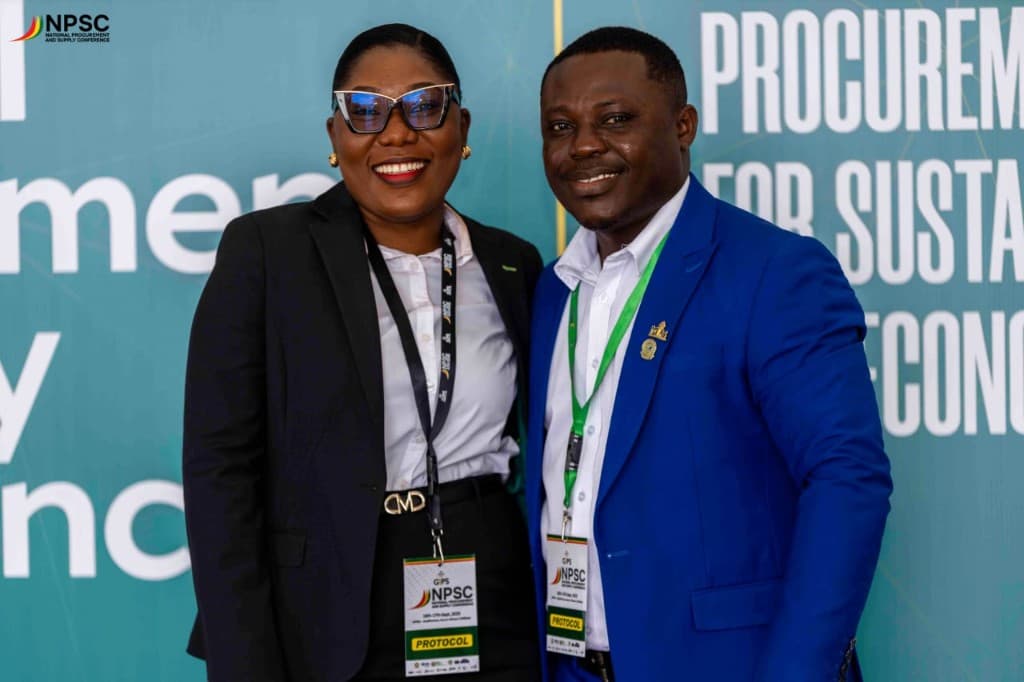 Two delegates posing in front of the NPSC backdrop